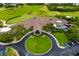 Aerial view of the clubhouse, which has a circular drive, manicured landscaping and a serene golf course backdrop at 8999 Wildlife Loop, Sarasota, FL 34238