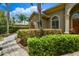 The exterior of the home features manicured bushes, lush tropical landscaping and a brick walkway at 8999 Wildlife Loop, Sarasota, FL 34238