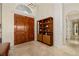 The foyer showcases a double door entry, travertine flooring, and a built in bookcase at 8999 Wildlife Loop, Sarasota, FL 34238