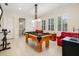 Game room with pool table, seating, and natural light from multiple windows with shutters at 8999 Wildlife Loop, Sarasota, FL 34238
