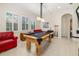Game room featuring a pool table, windows with plantation shutters, and a leather couch at 8999 Wildlife Loop, Sarasota, FL 34238