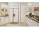 Kitchen featuring built-in refrigerator, dishwasher, and custom white cabinetry at 8999 Wildlife Loop, Sarasota, FL 34238