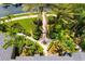 Lush landscaping surrounds the paver walkway and driveway with manicured shrubbery, tropical palm trees and green lawns at 8999 Wildlife Loop, Sarasota, FL 34238