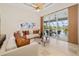 Well-lit living room with glass doors leading to an outdoor patio, stylish seating, and art at 8999 Wildlife Loop, Sarasota, FL 34238