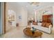 Bright living room featuring a modern white sofa, unique coffee table, and open access to the kitchen and dining area at 8999 Wildlife Loop, Sarasota, FL 34238