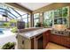 This screened-in outdoor kitchen is equipped with modern appliances and counter space perfect for entertaining at 8999 Wildlife Loop, Sarasota, FL 34238