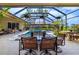 This inviting outdoor dining area is perfect for enjoying meals and relaxing by the screened-in pool at 8999 Wildlife Loop, Sarasota, FL 34238