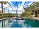 Beautiful swimming pool and spa area with a screened-in lanai and lake view at 8999 Wildlife Loop, Sarasota, FL 34238