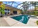 Inviting screened-in pool and spa with brick patio and outdoor seating, perfect for relaxation and entertaining at 8999 Wildlife Loop, Sarasota, FL 34238