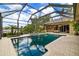 View of the private pool and spa surrounded by lush landscaping and screened lanai at 8999 Wildlife Loop, Sarasota, FL 34238