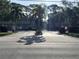 View of the community's gated entrance, surrounded by mature trees and well-maintained landscaping at 900 La Costa Cir # 4, Sarasota, FL 34237