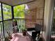 This screened patio has plants and a chair to sit and enjoy the outdoors at 900 La Costa Cir # 4, Sarasota, FL 34237