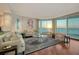 Bright living room featuring floor-to-ceiling windows with water views and elegant contemporary furniture at 990 Blvd Of The Arts # 801, Sarasota, FL 34236