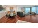An open floor plan integrates a dining area and living room with large windows overlooking water views at 990 Blvd Of The Arts # 801, Sarasota, FL 34236