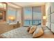 Comfortable main bedroom showcasing sunset water views, custom storage and a sitting area at 990 Blvd Of The Arts # 801, Sarasota, FL 34236
