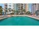Stunning pool surrounded by palm trees, luxurious loungers, and building views for relaxation and leisure at 990 Blvd Of The Arts # 801, Sarasota, FL 34236