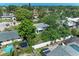Overhead view of a backyard featuring a pool, trampoline, and lush greenery in a cozy residential setting at 10095 Nassau Ct, Seminole, FL 33776