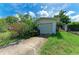Garage featuring a driveway, grass, and floral bushes at 10095 Nassau Ct, Seminole, FL 33776