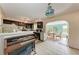 Cozy kitchen featuring dark cabinetry, tile flooring, and an adjacent dining area filled with natural light at 10095 Nassau Ct, Seminole, FL 33776