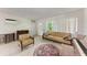 Bright living room with tile flooring, vintage furniture, and window views at 10095 Nassau Ct, Seminole, FL 33776