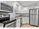 Modern kitchen featuring white cabinets, granite countertops, and stainless steel appliances at 101 S Gulfstream Ave # 15C, Sarasota, FL 34236