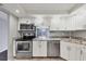 Updated kitchen with white cabinets, granite counters, and stainless steel appliances at 101 S Gulfstream Ave # 15C, Sarasota, FL 34236