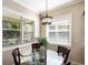 This breakfast nook features a glass table, four chairs, pendant lighting, and large windows at 11610 Griffith Park Ter, Bradenton, FL 34211