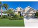 Charming home with a well-maintained lawn, mature palm trees, and an attached two-car garage, offering curb appeal and convenience at 11610 Griffith Park Ter, Bradenton, FL 34211
