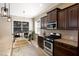 Bright kitchen with granite countertops, a stainless steel stove, dark wood cabinets, and natural light creating a functional area at 11610 Griffith Park Ter, Bradenton, FL 34211