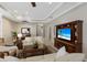 A living room with neutral walls, a ceiling fan, a television, and views to the front door at 11610 Griffith Park Ter, Bradenton, FL 34211