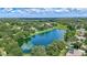 Beautiful aerial view of community lake surrounded by lush landscaping and mature trees at 13640 2Nd E Ave, Bradenton, FL 34212