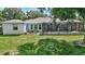 Spacious backyard with a screened-in pool, outdoor seating area, and lush green lawn at 13640 2Nd E Ave, Bradenton, FL 34212