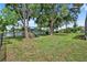 Large backyard with mature trees and a play set, offering ample space for recreation and Gathering fun at 13640 2Nd E Ave, Bradenton, FL 34212
