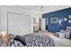 Stylish bedroom with a blue accent wall, comfortable bed, dresser, and closet at 13640 2Nd E Ave, Bradenton, FL 34212