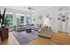 Bright living room featuring a large sectional sofa, statement rug, and natural light from large windows overlooking the backyard at 13640 2Nd E Ave, Bradenton, FL 34212
