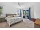 Primary bedroom with ceiling fan, carpet flooring, and access to the lanai at 13640 2Nd E Ave, Bradenton, FL 34212