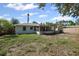Exterior back of home featuring an enclosed patio, shed, and ample green space at 1404 Dartmouth Dr, Bradenton, FL 34207