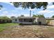 Exterior back of home with an enclosed patio, shed, and grass covered yard at 1404 Dartmouth Dr, Bradenton, FL 34207