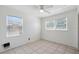 Cozy bedroom features tile floors, a ceiling fan, and two windows for natural light at 1404 Dartmouth Dr, Bradenton, FL 34207