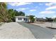 Quaint one-story home with a driveway and rock landscaping, complimented by lush, mature trees at 1404 Dartmouth Dr, Bradenton, FL 34207