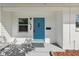 Charming home entrance featuring a bright blue door, white siding, and clear numbering at 1404 Dartmouth Dr, Bradenton, FL 34207