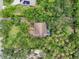 Aerial view of home nestled among mature trees, features backyard pool and solar panels on a neighboring property at 1509 Shadow Ridge Cir, Sarasota, FL 34240