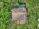 Aerial view showcasing the property's roof, pool, and the surrounding lush landscaping and trees at 1509 Shadow Ridge Cir, Sarasota, FL 34240