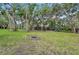 Spacious backyard with fire pit, mature trees, and lush landscaping perfect for outdoor gatherings at 1509 Shadow Ridge Cir, Sarasota, FL 34240