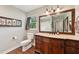 This bathroom has a wooden vanity with drawers and countertop, a large mirror and a toilet at 1509 Shadow Ridge Cir, Sarasota, FL 34240
