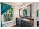 Bathroom with wood-style vanity, double sinks, large mirror and bright window at 1509 Shadow Ridge Cir, Sarasota, FL 34240