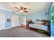 Bright bedroom with blue walls, wooden floors, a ceiling fan, area rug, and closet at 1509 Shadow Ridge Cir, Sarasota, FL 34240