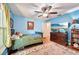 Bright bedroom with blue walls, wooden floors, a ceiling fan, area rug and a TV at 1509 Shadow Ridge Cir, Sarasota, FL 34240