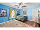 Bright bedroom with blue walls, wooden floors, a ceiling fan, area rug and a window at 1509 Shadow Ridge Cir, Sarasota, FL 34240