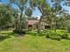 Charming home exterior with lush lawn, mature trees, and unique architectural details at 1509 Shadow Ridge Cir, Sarasota, FL 34240